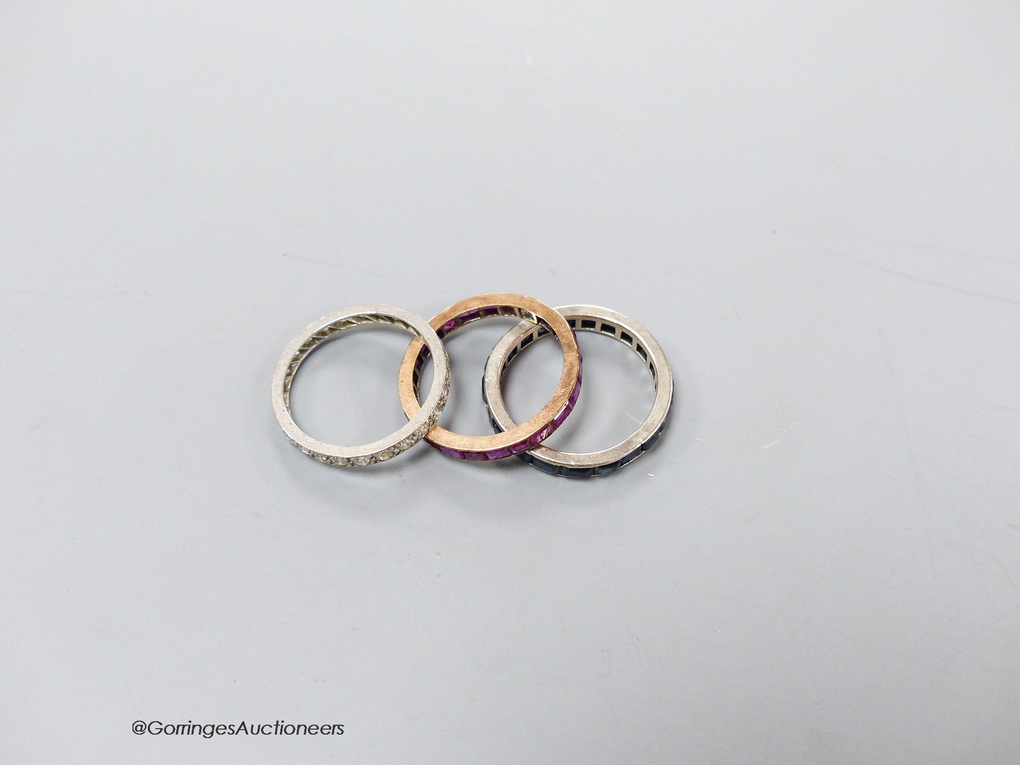 A white metal and diamond chip set full eternity ring, L/M, gross 2.2 grams and two other eternity rings.